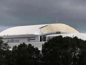 Part of the Retractible roof's membrane at Miami's Marlins Park stadium, where the Miami Marlins play baseball, is seen peeled off Monday, Sept. 11, 2017, in the wake of Hurricane Irma. (AP Photo/Wilfredo Lee)