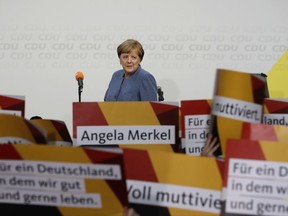 Supporters hold posters as German Chancellor Angela Merkel returns on the stage at the headquarters of the Christian Democratic Union CDU in Berlin, Germany, Sunday, Sept. 24, 2017 after the German parliament election. (AP Photo/Michael Sohn)
