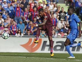 Barcelona's Paulinho, left, shoots to score the winning goal against Getafe during a Spanish La Liga soccer match between Getafe and Barcelona at the Alfonso Perez stadium in Getafe, outside Madrid, Saturday, Sept. 16, 2017.  (AP Photo/Francisco Seco)