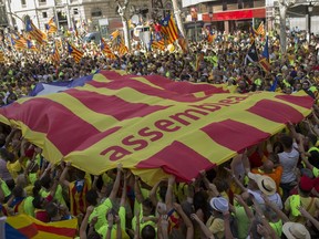 People holds up a giant estelada or independence flag during the Catalan National Day in Barcelona, Spain, Monday Sept. 11, 2017.Hundreds of thousands rally in Barcelona to show support for an independent Catalan nation and the right to vote in a controversial referendum that has been banned by Spain. (AP Photo/Francisco Seco)
