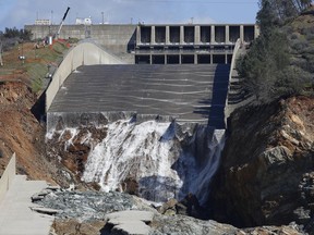 FILE - In this Feb. 28, 2017, file photo, water flows down the Oroville Dam's crippled spillway in Oroville, Calif. An independent team of dam experts says bad design and construction a half-century ago contributed to a disastrous spillway collapse at the nation's tallest dam. Dam-safety experts investigating February's spillway failures at the Oroville Dam say California should have assessed the original flaws. (AP Photo/Rich Pedroncelli, File)