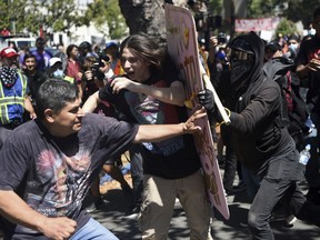 FILE - In this Sunday, Aug. 27, 2017, file photo, demonstrators clash during a free speech rally, in Berkeley, Calif. Police in the city of Berkeley can use pepper spray on violent demonstrators after the City Council voted Tuesday, Sept. 12, to allow police to use pepper spray to repel attacks on officers and others during the kind of violent protests that have rocked the city this year. (AP Photo/Josh Edelson)