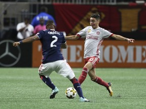 Atlanta United midfieldeer Miguel Almiron works with the ball as New England Revolution's Andrew Farrel (2) defends during an MLS soccer match Wednesday, Sept. 13, 2017, in Atlanta. (Miguel Martinez/Atlanta Journal-Constitution via AP)