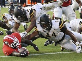 Georgia running back Sony Michel gets past Appalachian State defenders A.J. Howard, top, and Anthony Flory for a touchdown during the second quarter of an NCAA college football game Saturday, Sept. 2, 2017, in Athens, Ga. (Curtis Compton/Atlanta Journal-Constitution via AP)