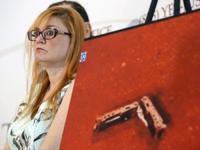 Lynne Schultz, mother of Scout Schultz, stands beside an enlarged photograph of a multipurpose tool at a news conference in Atlanta, Ga., Monday, Sept. 18, 2017. Scout was a 21-year-old Georgia Tech student who was shot and killed while holding the tool during a confrontation with police on campus Saturday, Sept. 16. (Casey Sykes/Atlanta Journal-Constitution via AP)