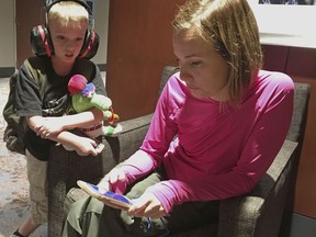 Pam Szymanski of Fort Myers, Fla. and her 8-year-old son Charlie Dutill watch weather radar on Monday, Sept. 11, 2017, as the remnants of Irma move toward metro Atlanta, where their family evacuated to a downtown hotel. Szymanski said her Florida home suffered some wind damage, but she doesn't know how much and isn't sure when she will be able to return. (AP Photo/Bill Barrow)