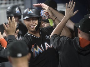 Miami Marlins' Giancarlo Stanton celebrates in the dugout after scoring against the Atlanta Braves during the ninth inning of a baseball game, Friday, Sept. 8, 2017, in Atlanta. Miami won 7-1. (AP Photo/John Amis)