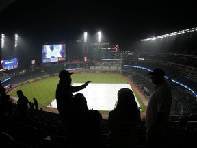 Baseball fans wait out a rain delay before the start of a scheduled a baseball game between Atlanta Braves and Texas Rangers, Tuesday, Sept. 5, 2017, in Atlanta. (AP Photo/John Bazemore)