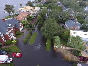 In this Monday, Sept. 11, 2017, photo provided by DroneBase, people trudge through floodwaters in the aftermath of Hurricane Irma in Jacksonville, Fla. In a parting blow to the state, the storm caused record flooding in the Jacksonville area. (DroneBase via AP)