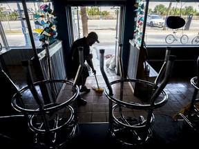 Fannie's By The Sea Manager Chris Jackson mops up his flooded restaurant Tuesday, Sept. 12, 2017, on Tybee Island, Ga., after Tropical Storm Irma flooded parts island. (AP Photo/Stephen B. Morton)
