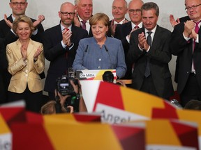 Angela Merkel, Germany's chancellor and Christian Democratic Union (CDU) leader, centre, reacts during celebrations following the federal elections at the CDU headquarters in Berlin, Germany.