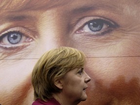 Angela Merkel walks past an election billboard, September 2005 in Prerow, northern Germany
