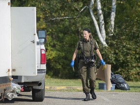 Quebec provincial police officers check a trailer for evidence in Lachute, Que., Friday, September 15 , 2017.