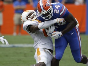 Tennessee's Justin Martin, left, tries to stop Florida running back Mark Thompson (24) after a short gain during the first half of an NCAA college football game, Saturday, Sept. 16, 2017, in Gainesville, Fla. (AP Photo/John Raoux)
