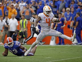 Tennessee running back John Kelly (4) scores a touchdown past Florida linebacker David Reese (33) on a 34-yard run in the second half of an NCAA college football game, Saturday, Sept. 16, 2017, in Gainesville, Fla. Florida won 26-20. (AP Photo/John Raoux)