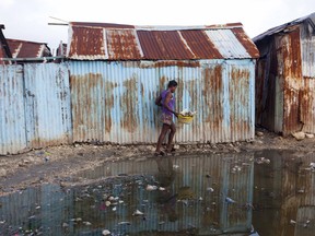 A woman skirts a puddle as she walks home in Port-au-Prince, Haiti, Wednesday, Sept. 6, 2017. Heavy rain and 185-mph winds lashed the Virgin Islands and Puerto Rico's northeast coast Wednesday as Hurricane Irma roared through Caribbean islands. The northern parts of the Dominican Republic and Haiti could see 10 inches of rain.