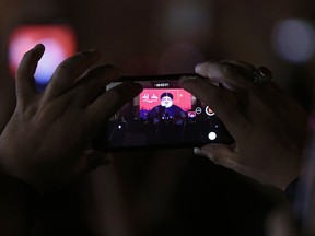 Hezbollah leader Sheik Hassan Nasrallah, is displayed on a mobile phone as he delivers a message via video link, during the ninth of Ashura, a 10-day ritual commemorating the death of Imam Hussein, in a southern suburb of Beirut, Lebanon, Saturday, Sept. 30, 2017. Ashoura is the annual Shiite Muslim commemoration marking the death of Imam Hussein, the grandson of the Prophet Muhammad, at the Battle of Karbala in present-day Iraq in the 7th century. (AP Photo/Hassan Ammar)
