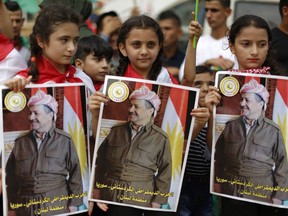 Kurdish girls hold posters  showing Iraqi Kurdish leader Masoud Barzani as they gather to support next week's referendum in Iraq, at Martyrs Square in Downtown Beirut, Lebanon, Sunday, Sept. 17, 2017. Iraq's Kurdish region plans to hold the referendum on Sept. 25 to gauge support for independence from Iraq for the autonomous region. (AP Photo/Hassan Ammar)