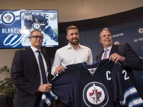 In this Aug. 31, 2016 file photo, Winnipeg Jets head coach Paul Maurice (left) and GM Kevin Cheveldayoff (right) pose with forward Blake Wheeler.