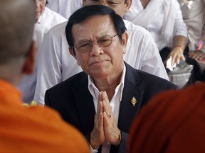 In this Thursday, March 30, 2017, file photo, opposition leader of the Cambodia National Rescue Party Kem Sokha prays during a Buddhist ceremony to mark the 20th anniversary of the attack on anti-government protesters in 1997, in Phnom Penh, Cambodia. Police have arrested the Kem in a surprise raid on his home early Sunday, Sept. 3, 2017. The government issued a statement accusing Kem Sokha of treason, saying he conspired with foreign powers against Cambodia. (AP Photo/Heng Sinith, File)