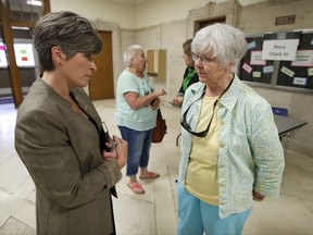 U.S. Sen. Joni Ernst, R-Iowa, talks with Donna Masmar, of Stanton, Iowa, right, before speaking at a town hall meeting, Thursday, Sept. 21, 2017, in Charles City, Iowa. (AP Photo/Charlie Neibergall)