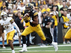 Iowa tight end Noah Fant (87) catches a 27-yard touchdown pass between Wyoming's Tyler Hall, left, and Cassh Maluia, right, during the first half of an NCAA college football game, Saturday, Sept. 2, 2017, in Iowa City, Iowa. (AP Photo/Charlie Neibergall)