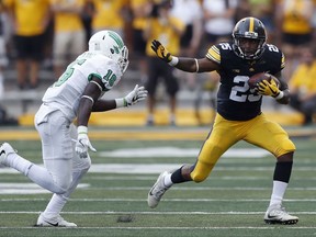 Iowa running back Akrum Wadley runs from North Texas defensive back Kemon Hall, left, after catching a pass during the first half of an NCAA college football game, Saturday, Sept. 16, 2017, in Iowa City, Iowa. (AP Photo/Charlie Neibergall)