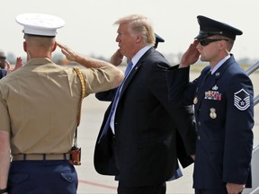 President Donald Trump is saluted as he steps off Air Force One, Wednesday, Sept. 27, 2017, in Indianapolis. (AP Photo/Alex Brandon)