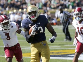Notre Dame running back Josh Adams (33) sprints to the end zone for a touchdown past Temple defensive back Sean Chandler (3) and Mike Jones (10) during the first half of an NCAA college football game Saturday, Sept. 2, 2017, in South Bend, Ind. (AP Photo/Charles Rex Arbogast)