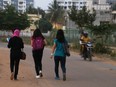 A motorist rides past young women in India, Wednesday, Jan. 4, 2017