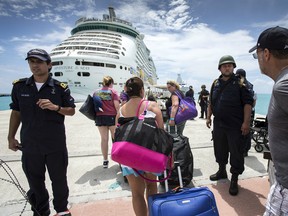 This photo provided by the Dutch Defense Ministry on Sunday, Sept. 10, 2017, shows people walking toward a cruise ship anchored on St. Maarten, after the passage of Hurricane Irma. Irma cut a path of devastation across the northern Caribbean, including this island that is split between French and Dutch control.
