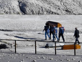 The coffins of three people who died when they fell into a crater in a steamy volcanic field in Pozzuoli, near Naples, Italy, are carried away Tuesday, Sept. 12, 2017. Italian news reports say an 11-year-old Italian boy and his parents died in a steamy volcanic field near Naples.
