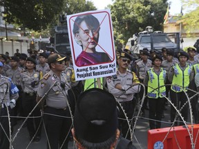 A Muslim man displays a defaced poster of Myanmar's State Counsellor Aung San Suu Kyi during a rally against the persecution of Rohingya Muslims outside Myanmar Embassy in Jakarta, Indonesia, Friday, Sept. 8, 2017. Dozens of Muslims staged the rally condemning violence in Myanmar against its Rohingya minority. Writings on the poster read: "Perpetrator of crimes against humanity." (AP Photo/Tatan Syuflana)