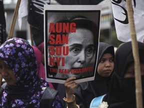 A Muslim woman holds a poster of Myanmar's State Counsellor Aung San Suu Kyi during a rally against the persecution of Rohingya Muslims in Medan, North Sumatra, Indonesia, Wednesday, Sept. 6, 2017. Several thousand people marched across the world's most populous Muslim nation on Wednesday, calling on the government to put more pressure on Myanmar to halt the persecution of its Rohingya Muslim minority. (AP Photo/Binsar Bakkara)