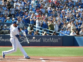 Toronto Blue Jays' Jose Bautista hits a single in front of an applauding crowd against the New York Yankees during the first inning of a baseball game Sunday, September 24, 2017 in Toronto. This may be Bautista's last home game as a Blue Jay. THE CANADIAN PRESS/Jon Blacker