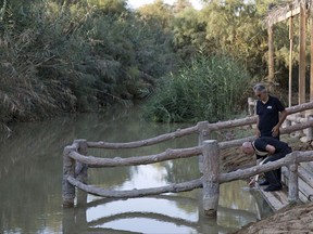 Italian star tenor Andrea Bocelli, 58, a Catholic, stands at the edge of the Jordan River as a priest scoops up water to pour it over Bocelli's hands, at Al-Maghtas, Jordan. Bocelli prayed at the traditional site of Jesus' baptism, made the sign of the cross with river water and told The Associated Press that he "prayed for peace in the world." (Elena Boffetta/Jordan Tourism Board via AP)