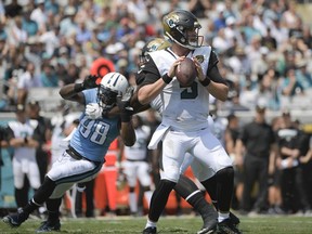 Jacksonville Jaguars quarterback Blake Bortles, right, looks for a receiver as he is pressured by Tennessee Titans outside linebacker Brian Orakpo (98) during the first half of an NFL football game, Sunday, Sept. 17, 2017, in Jacksonville, Fla. (AP Photo/Phelan M. Ebenhack)