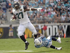 Jacksonville Jaguars running back Leonard Fournette (27) tries to break free from the grasp of Tennessee Titans cornerback Adoree' Jackson on a run during the first half of an NFL football game, Sunday, Sept. 17, 2017, in Jacksonville, Fla. (AP Photo/Phelan M. Ebenhack)
