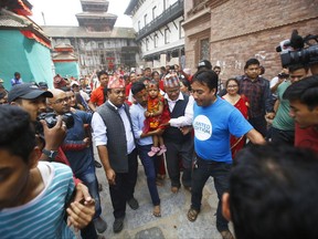 Nepal's new living goddess Trishna Shakya, 3, is carried by her father towards a temple palace in Kathmandu, Nepal, Thursday, Sept. 28, 2017. Shakya has become Nepal's new "Kumari," revered by both Hindus and Buddhists in the Himalayan nation. She was carried in a religious ceremony to a temple palace in the heart of the Nepalese capital where she is to live until just before puberty. (AP Photo/Bikram Rai)