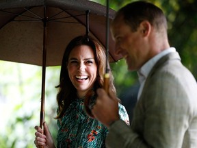 Prince William and his wife Kate, Duchess of Cambridge, walk through the memorial garden in Kensington Palace, London, on Aug. 30, 2017.