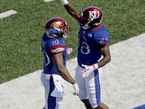 Kansas running back Khalil Herbert (10) celebrates with wide receiver Jeremiah Booker (88) after Herbert scored a touchdown during the first half of an NCAA college football game against the West Virginia, Saturday, Sept. 23, 2017, in Lawrence, Kan. (AP Photo/Charlie Riedel)