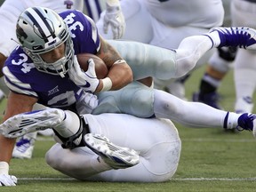 Kansas State running back Alex Barnes (34) lands on Central Arkansas defensive end Nathan Grant during the first half of an NCAA college football game in Manhattan, Kan., Saturday, Sept. 2, 2017. (AP Photo/Orlin Wagner)