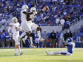 Eastern Michigan defensive back Vince Calhoun and defensive back Kevin McGill, with the ball, celebrate after McGill intercepted a pass over Kentucky wide receiver Isaiah Epps during the first half of an NCAA college football game Saturday, Sept. 30, 2017, in Lexington, Ky. The play was called back after a pass interference penalty against Eastern Michigan. (AP Photo/David Stephenson)