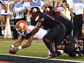 Clemson quarterback Kelly Bryant (2) is brought down by Louisville's Dorian Etheridge, front right, and Trumaine Washington (15) as he crosses the goal line during the first half of an NCAA college football game, Saturday, Sept. 16, 2017, in Louisville, Ky. (AP Photo/Timothy D. Easley)