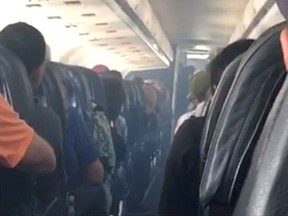 This frame from mobile phone video shows smoke inside an Allegiant Air jet after it landed at Fresno Yosemite International Airport in California's Central Valley, Monday, Sept. 25, 2017. Smoke filled the cabin of an Allegiant Air jet after it landed at the airport on Monday, forcing coughing passengers to cover their faces with shirts and firefighters to board the plane, authorities said. Allegiant said no passengers or any of the six crew members were injured. (Estevan Moreno via AP)