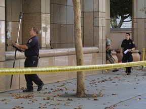 Authorities investigate an officer involved shooting at The Ronald Reagan State Office Building in downtown Los Angeles on Wednesday, Sept. 6, 2017. A man with a bag over his hands followed an employee into the building took "an aggressive shooting stance" and ordered workers to the ground before an officer fatally shot him. (AP Photo/Richard Vogel)