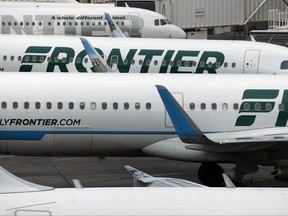 In this Monday, May 15, 2017, photograph, Frontier Airlines jets sit at gates on the A Concourse at Denver International Airport in Denver. The U.S. government has fined Frontier $1.5 million for keeping passengers stuck on a dozen grounded aircraft for more than three hours during a snowstorm at the Denver airport in December 2016. But the federal Department of Transportation said Friday, Sept. 15, 2017, it will forgive $900,000 of that because of compensation the airline says it paid to passengers. (AP Photo/David Zalubowski, File)