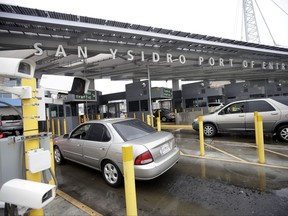 FILE - In this Dec. 3, 2014, file photo cars wait to enter the United States from Tijuana, Mexico through the San Ysidro port of entry in San Diego. Federal authorities say two people were hit by a car and killed as they sprinted from a van that sped across the border from Tijuana, Mexico, into San Diego County. Border Patrol agent Tekae Michael says the incident happened around 2 a.m. Sunday, Sept. 17, 2017, at the San Ysidro Port of Entry. (AP Photo/Gregory Bull, File)