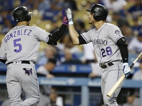 Colorado Rockies right fielder Carlos Gonzalez, left, is congratulated by Nolan Arenado after hitting a home run against the Los Angeles Dodgers during the first inning of a baseball game in Los Angeles, Friday, Sept. 8, 2017. (AP Photo/Alex Gallardo)