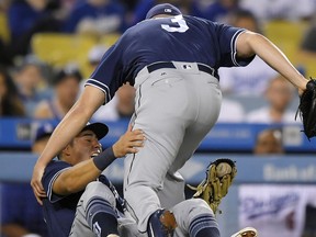 San Diego Padres starting pitcher Clayton Richard, top, and third baseman Christian Villanueva collide slightly as they both tried to field a foul ball hit by Los Angeles Dodgers' Austin Barnes during the second inning of a baseball game, Wednesday, Sept. 27, 2017, in Los Angeles. (AP Photo/Mark J. Terrill)